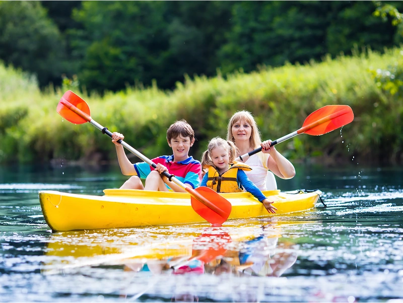 Family kayaking on a calm river.