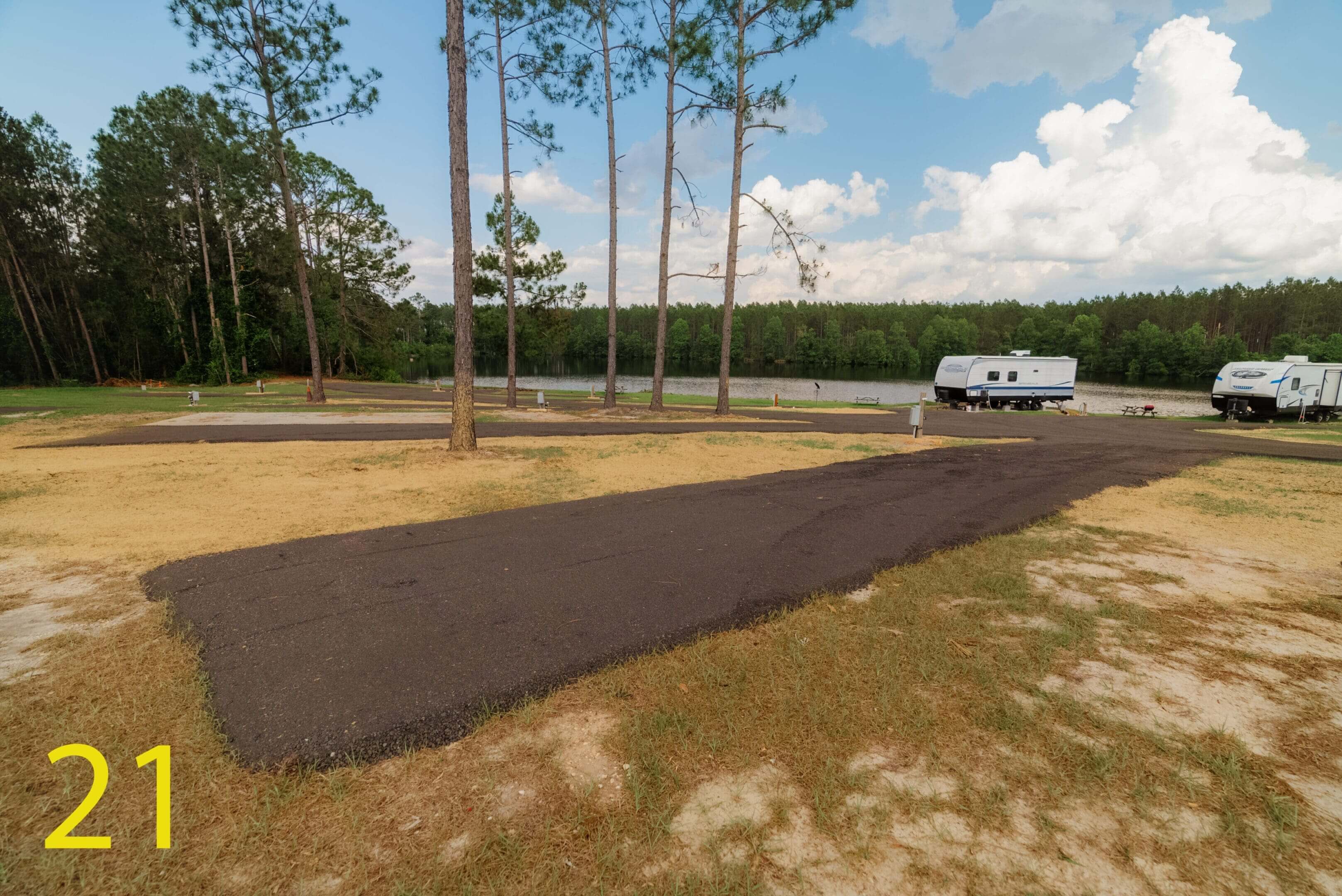 Freshly paved driveway leading to a white camper van.