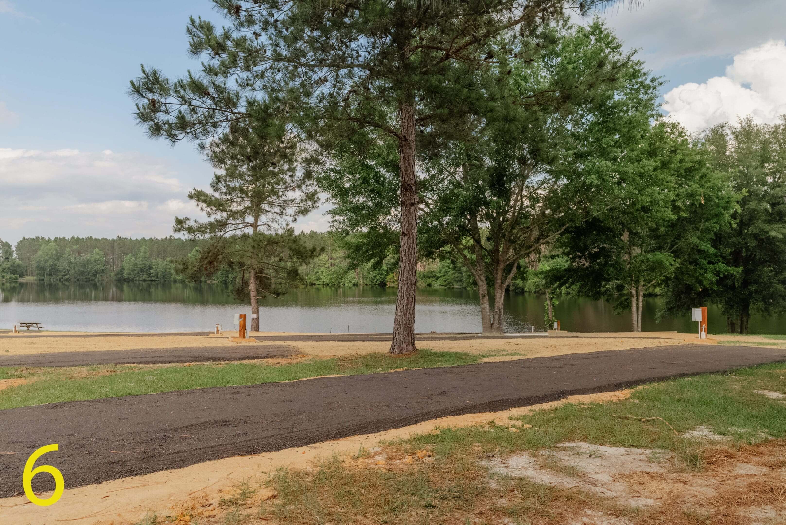 A person walking near a lake surrounded by trees.
